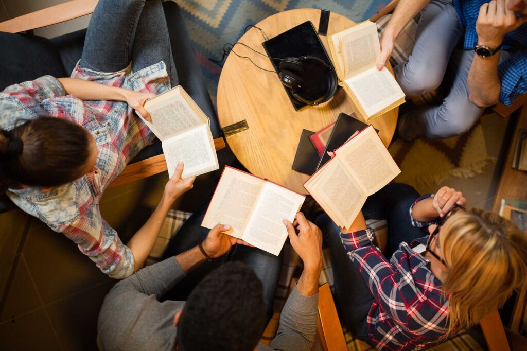 Diverse group of friends discussing a book in library