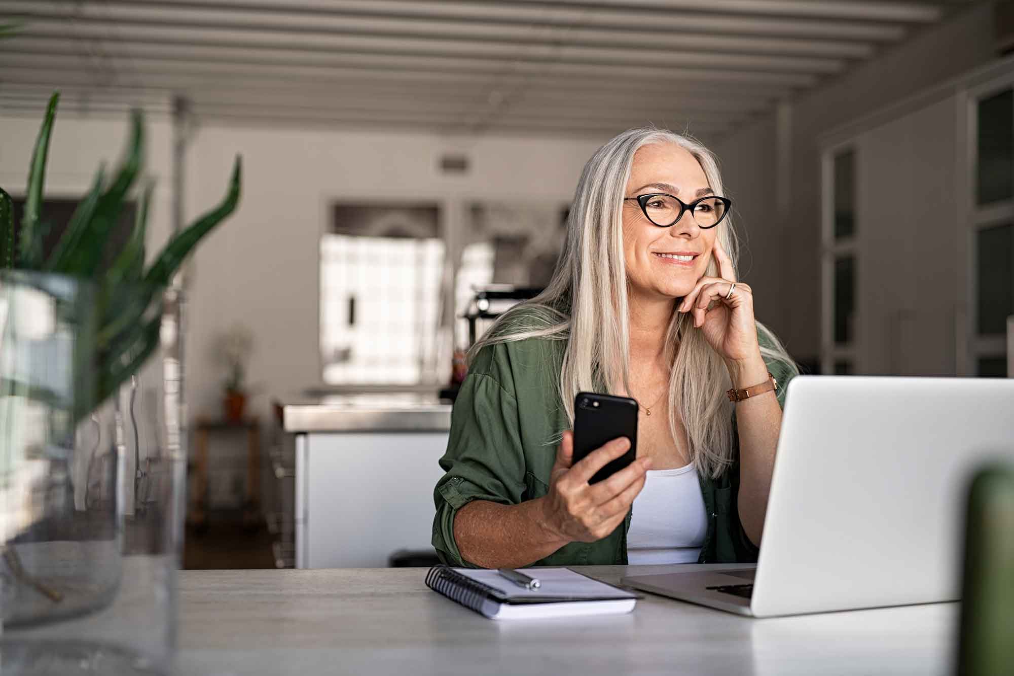 Happy senior woman holding smartphone