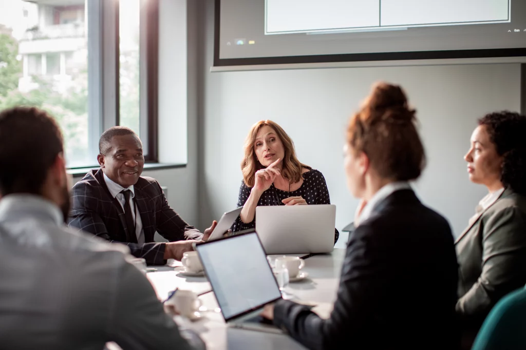 Group of diverse people in a meeting around a table.