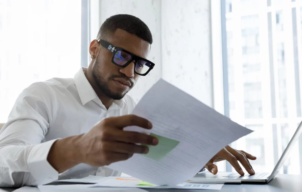 Man with glasses looking at paperwork.