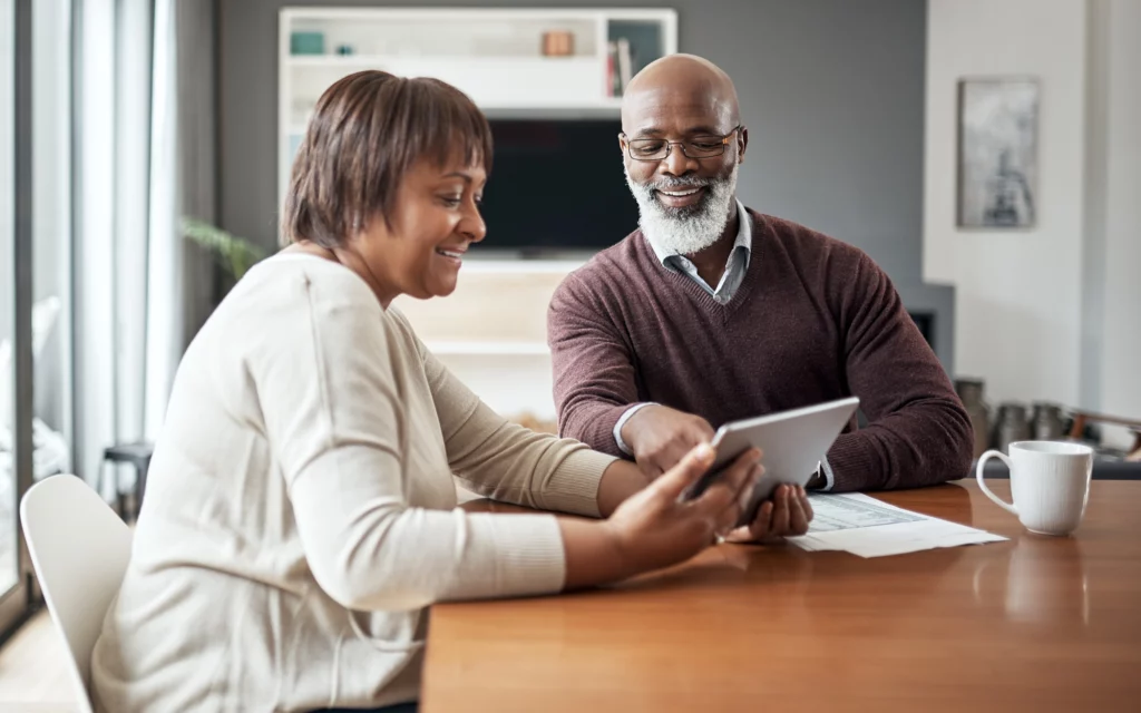 Older couple looking at paperwork in their dining room.