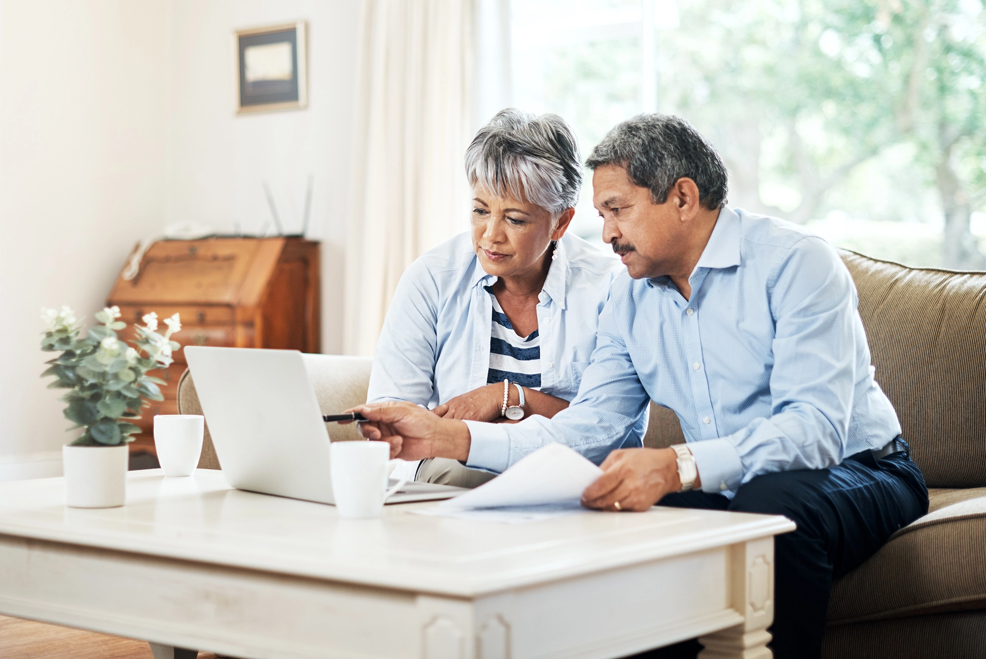 A couple in their living room looking at paperwork