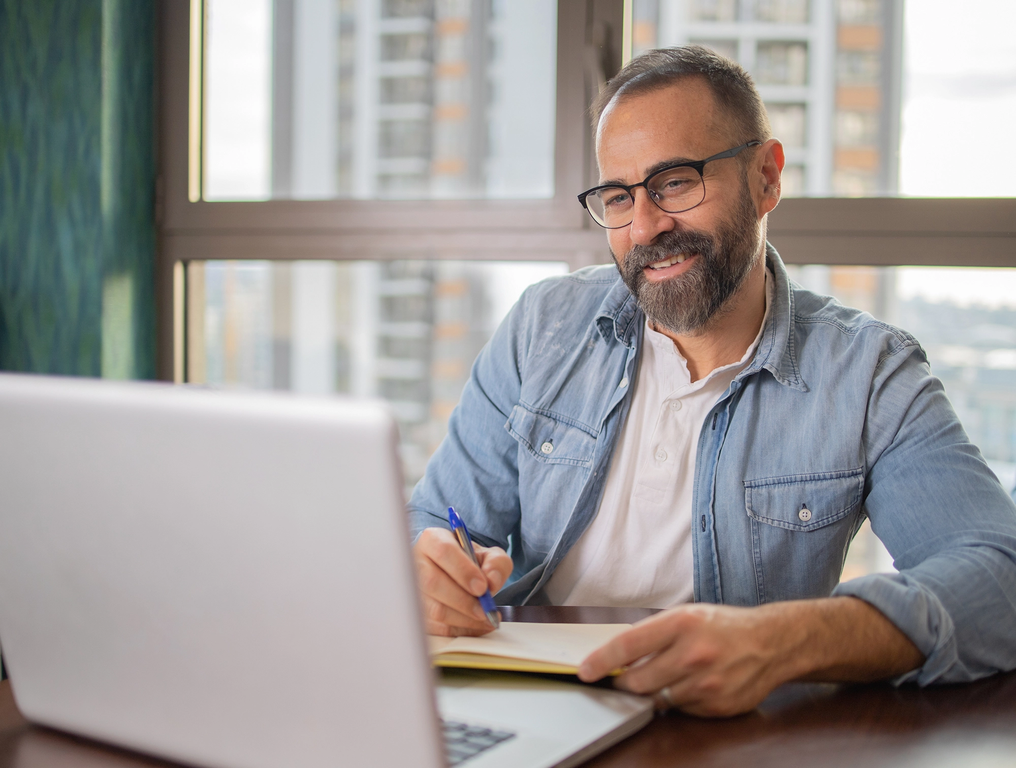 Man in glasses looking at laptop