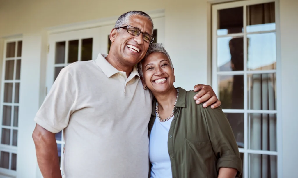 Senior couple hugging on their porch