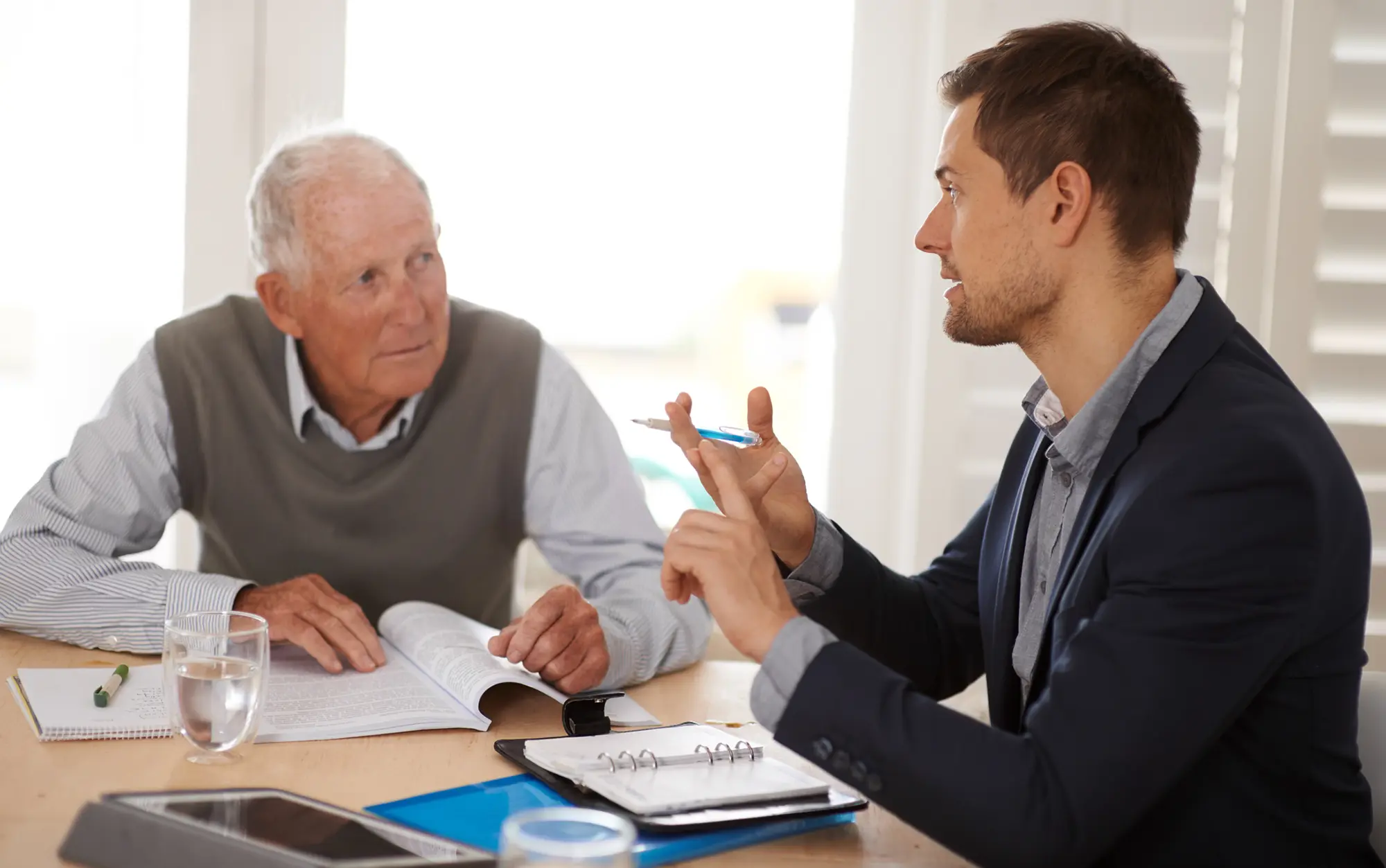 Two men sitting and discussing taxes.