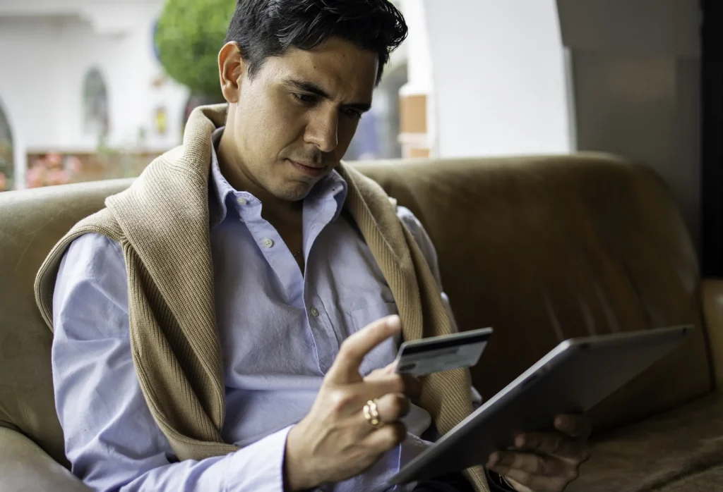 Young man looking at credit card.