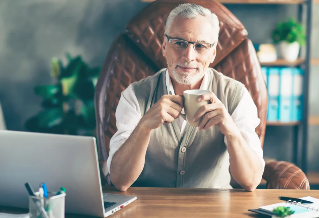 Senior man sitting at desk.