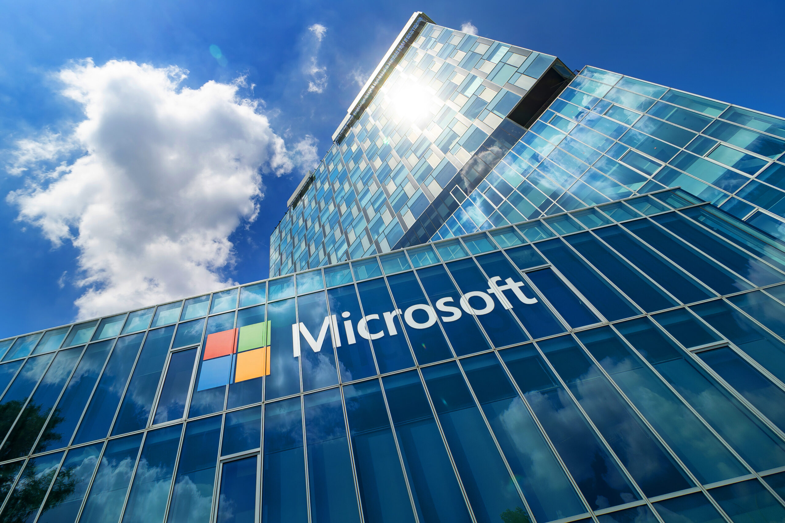 office building with Microsoft logo looking up from the bottom floor to the sky