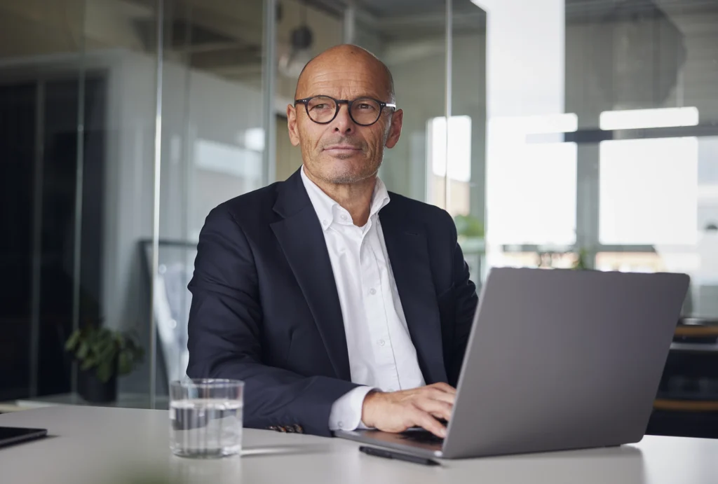 OCIO sitting at conference table with laptop