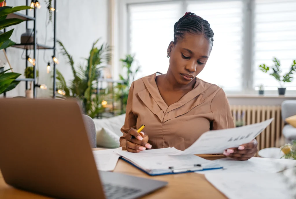 Woman at her desk looking through financial paperwork