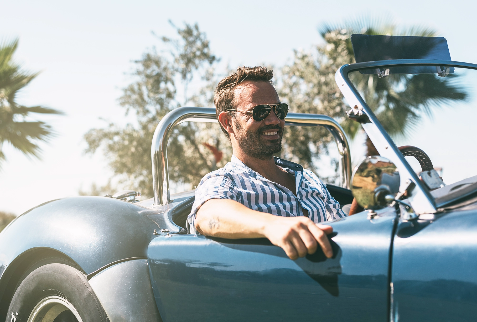 A man riding in a classic car he just invested in!