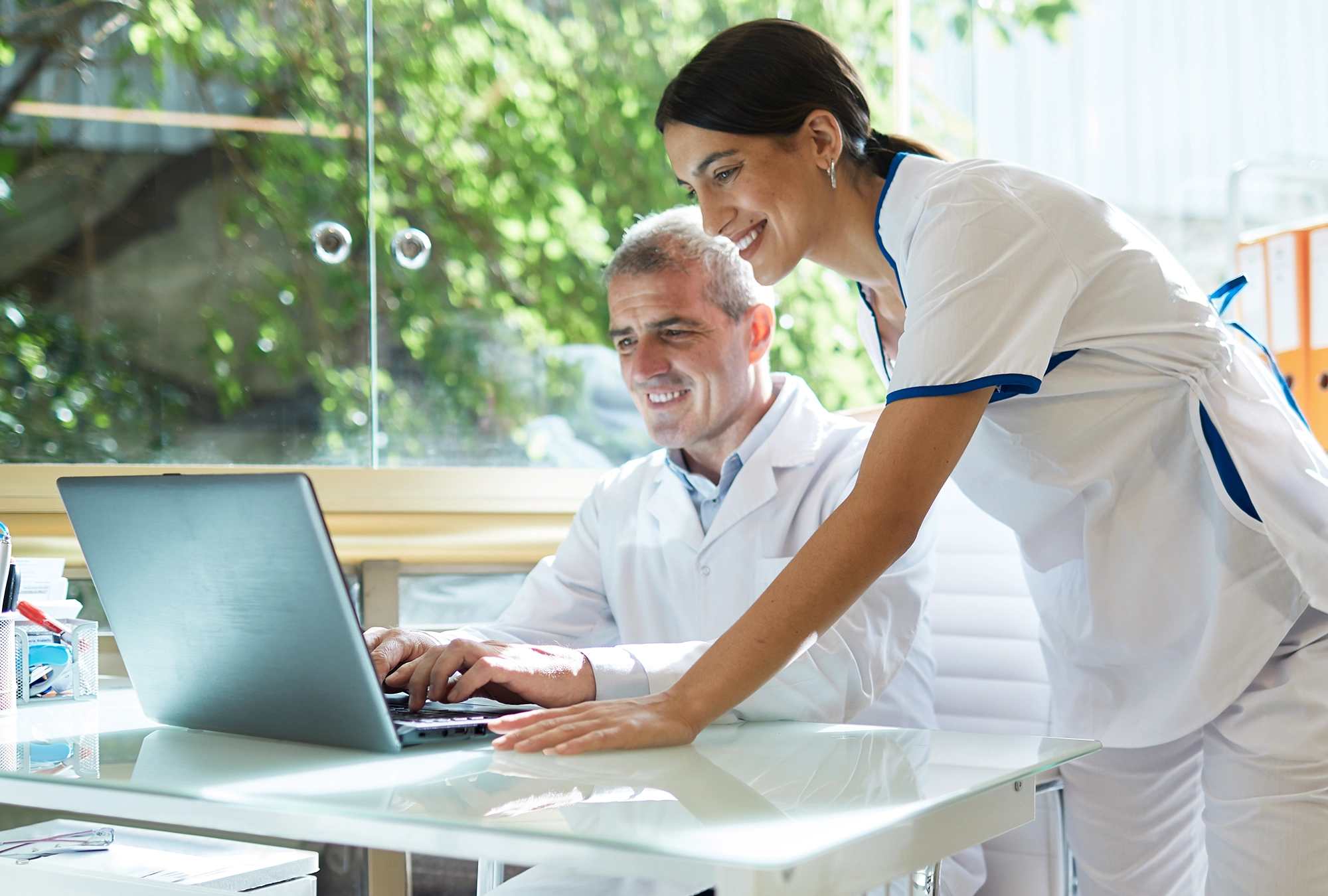 A dentist and his assistant looking at sale documents