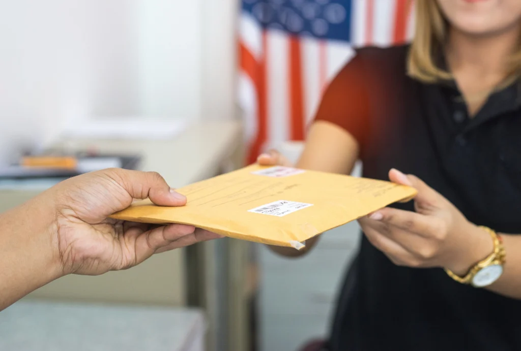 A lady handing someone a piece of mail